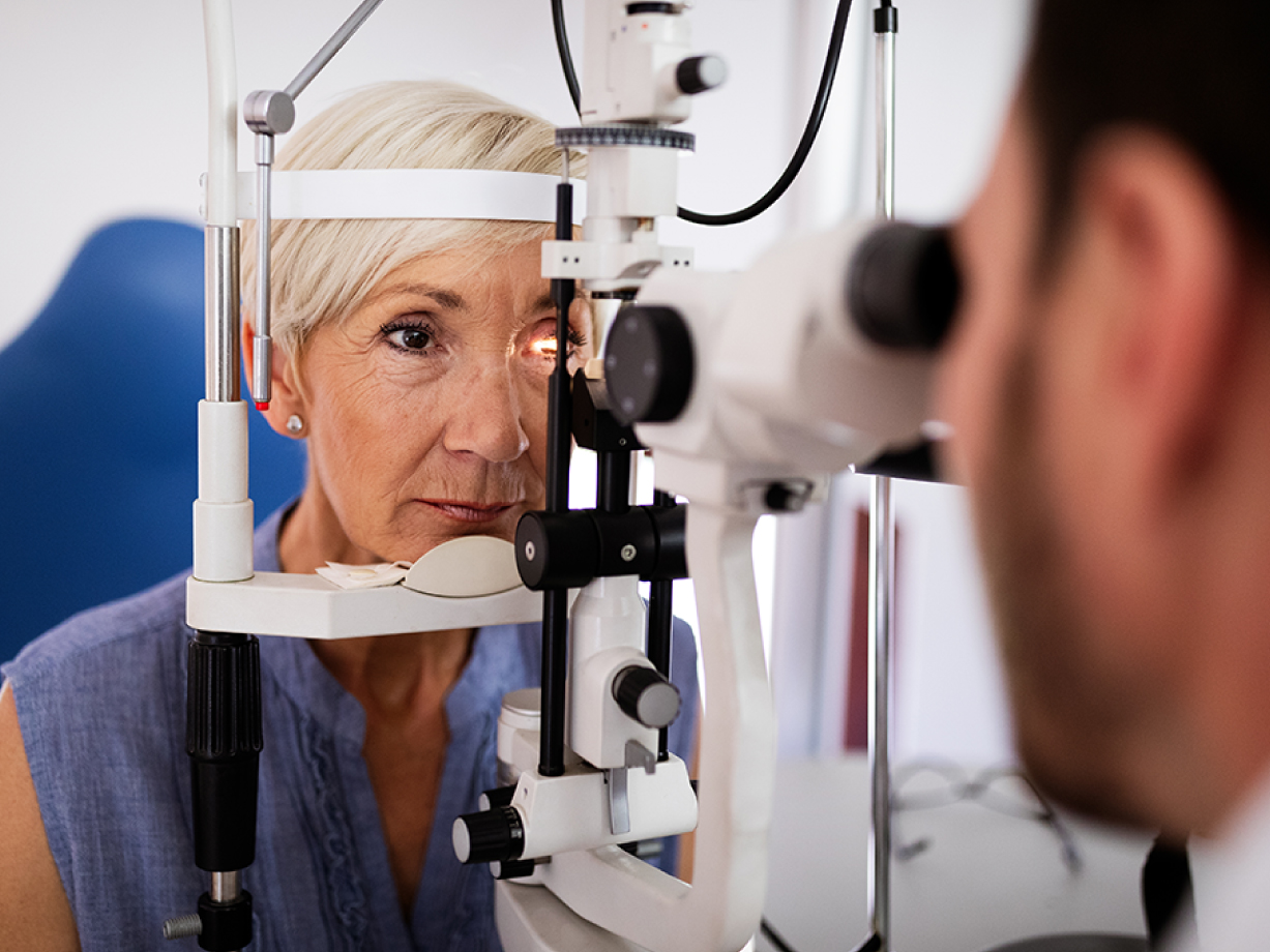 Retina specialist examining a patient's eyes with medical instruments in a clinic