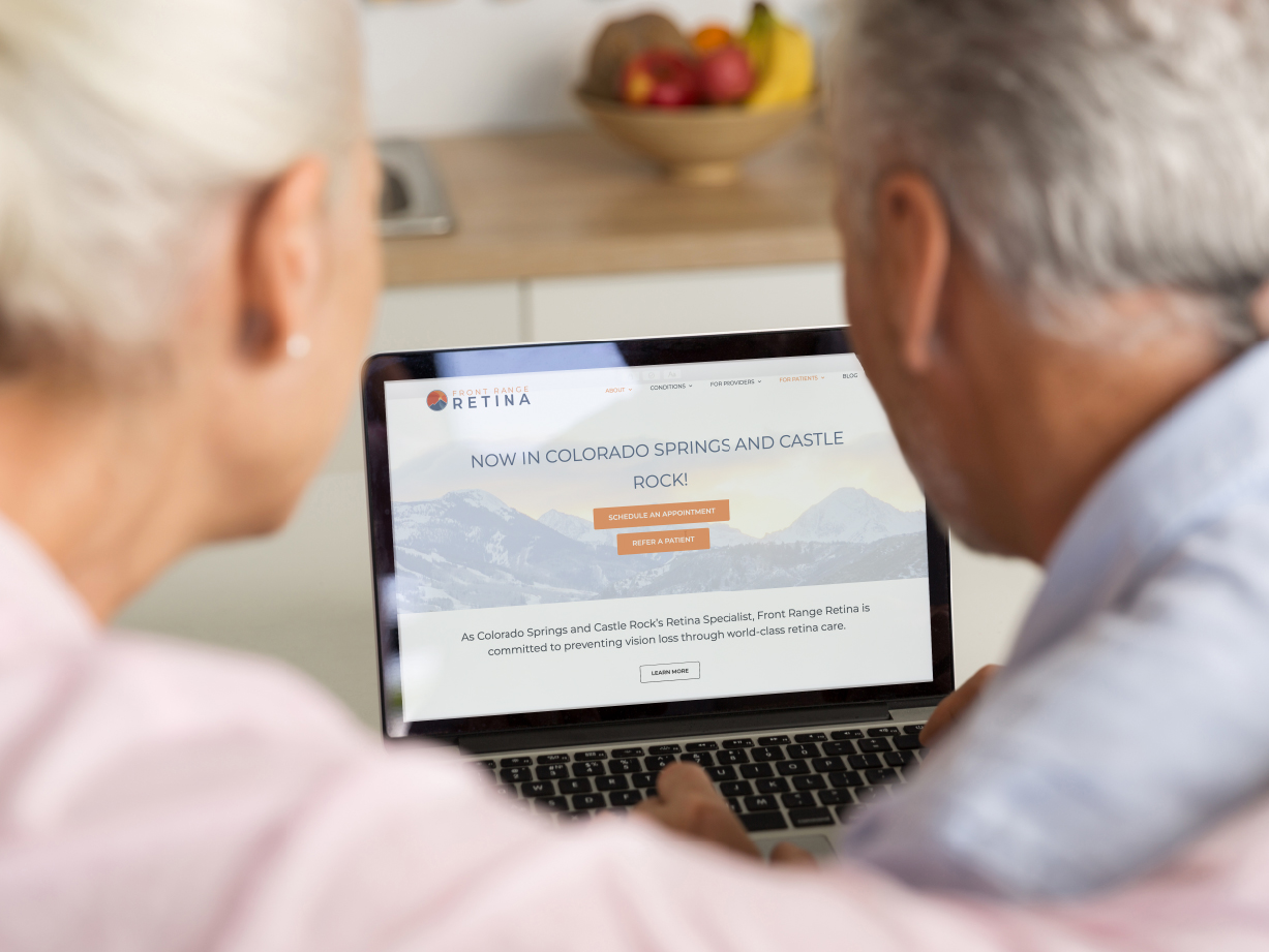 A couple at a laptop transferring their medical care to Front Range Retina